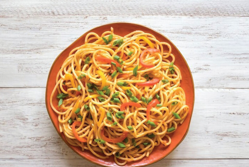 A plate of Veg-Noodles with colorful peppers and onions, creating a vibrant and flavorful dish.