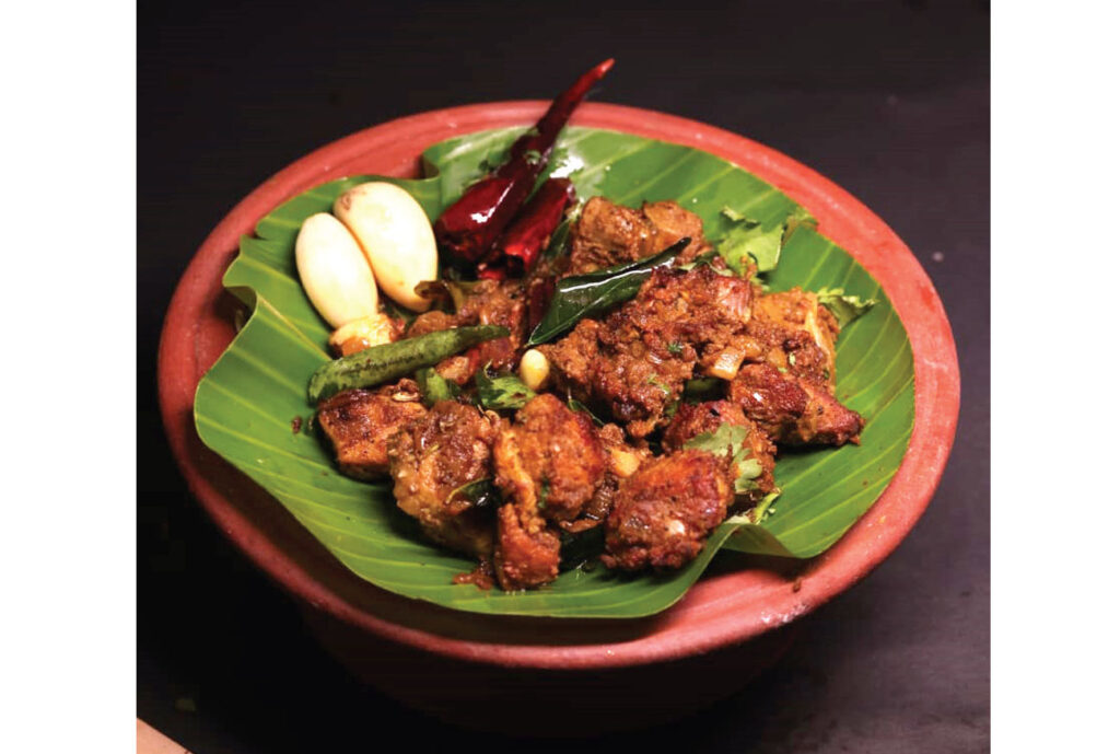Pallipalayam Chicken served with a banana leaf on a Plate.