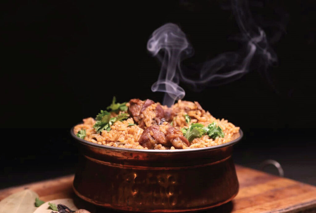 Spiced Mutton Biryani in a bowl on a wooden board.