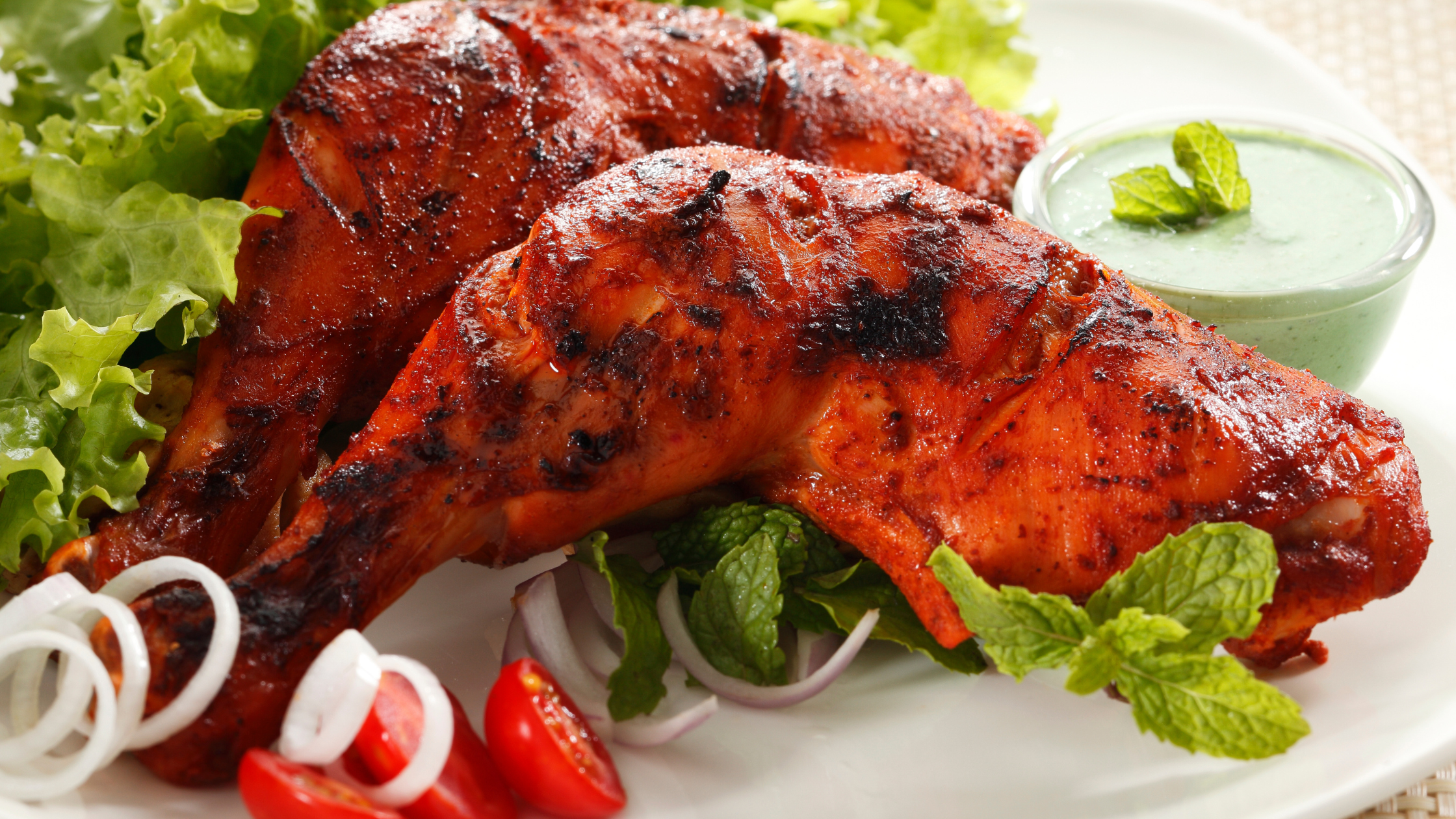 Tandoori Chicken served with Green Mint Chutney along with Onions and Tomatos