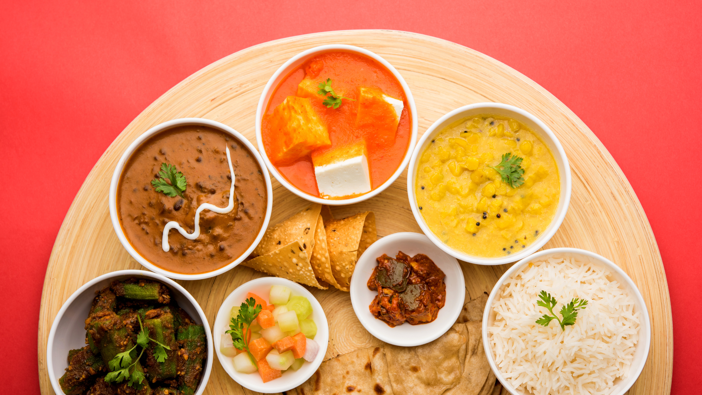 Group of Indian food served in the ceramic bowl. The foods are Nan, Ghee Rice, and Paneer Masala.