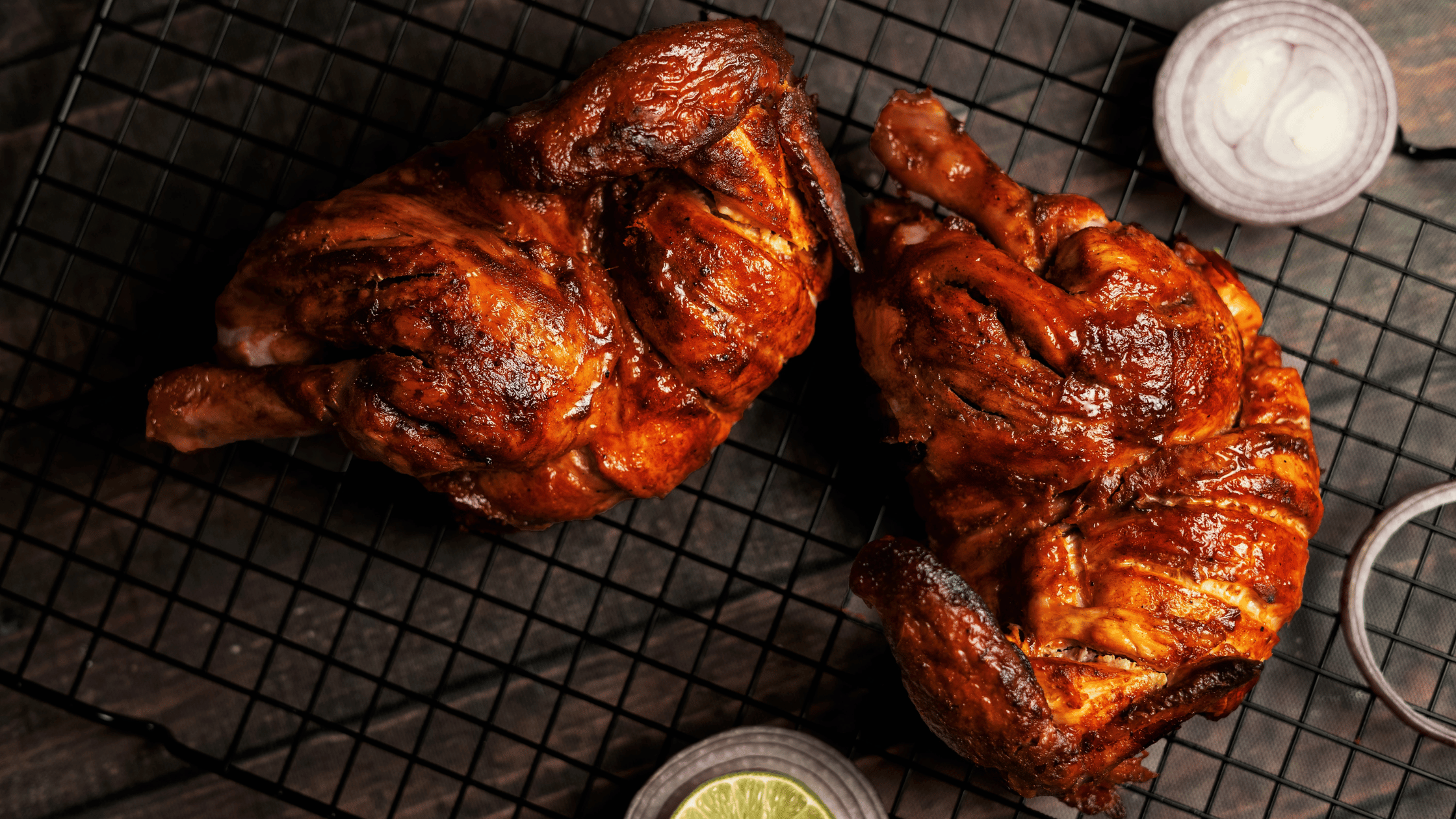 Grilled chicken placed on the grill with a slice of Lemon and Onion