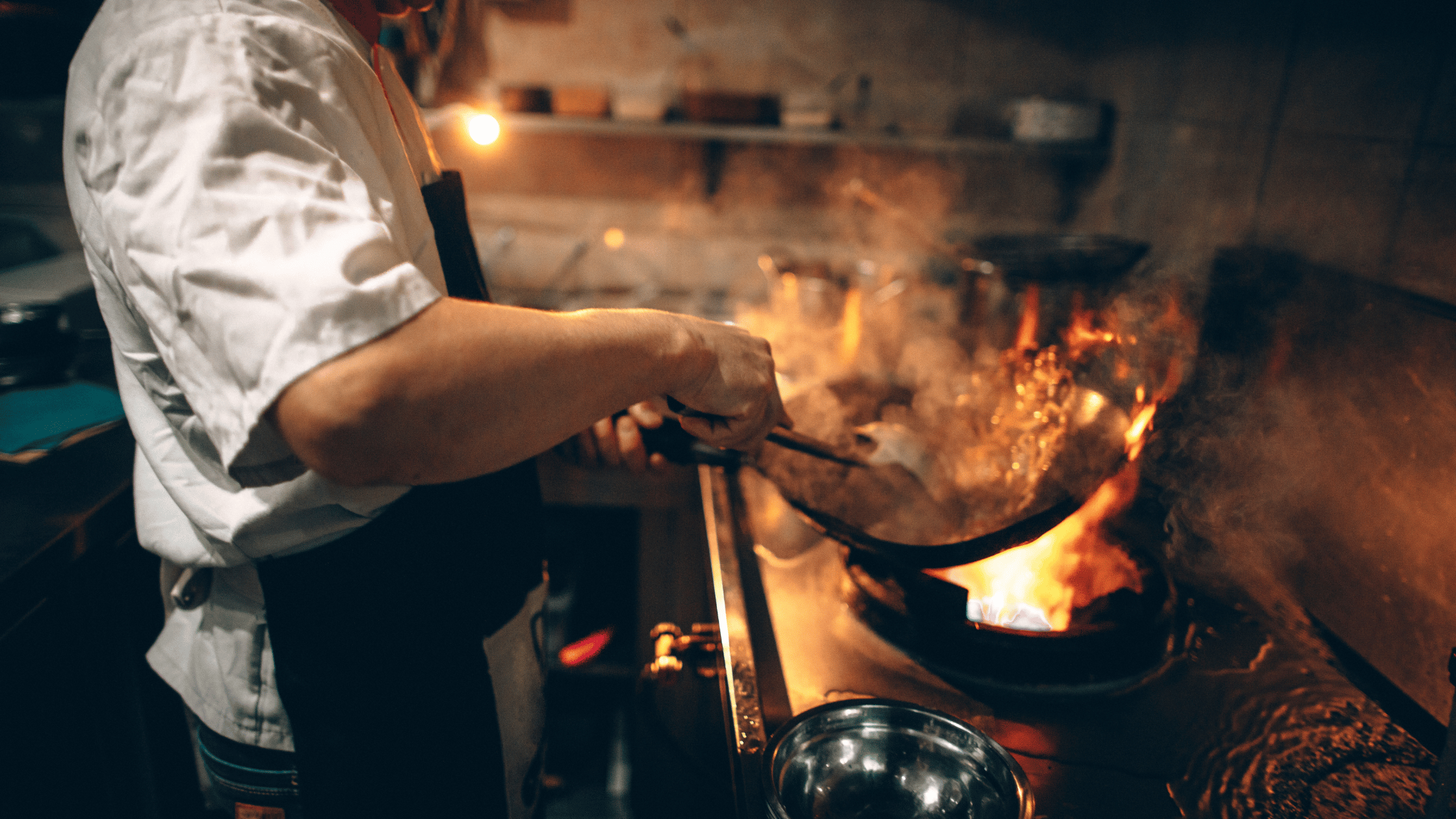 Chef cooking over an open flame in a lively kitchen, showcasing the art of preparing authentic Indian dishes with rich spices and bold flavors.