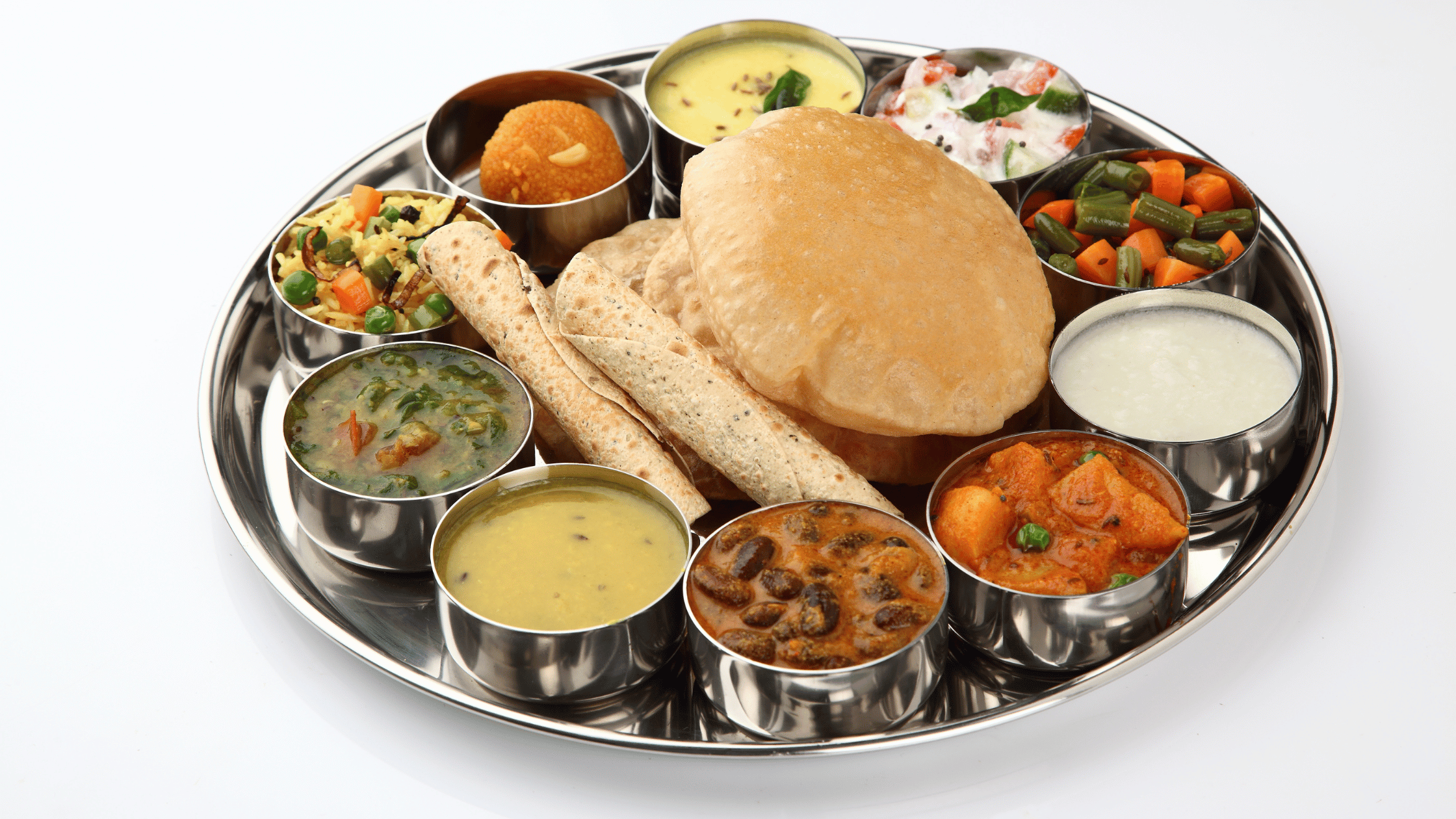 Traditional Indian thali with puri, chapati, rice, curries, dal, raita, and dessert – authentic Indian food platter in Austin, Texas